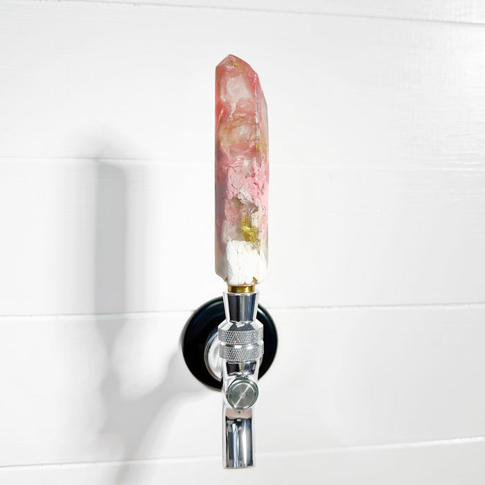 Decorative beer tap with a pink crystal handle on a white background