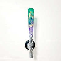Decorative beer tap handle with a colorful design on a white background