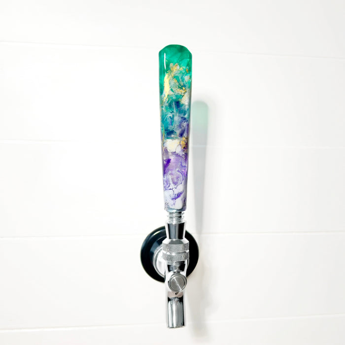 Decorative beer tap handle with a colorful design on a white background