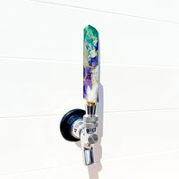 Decorative beer tap handle in purple and green with a white background